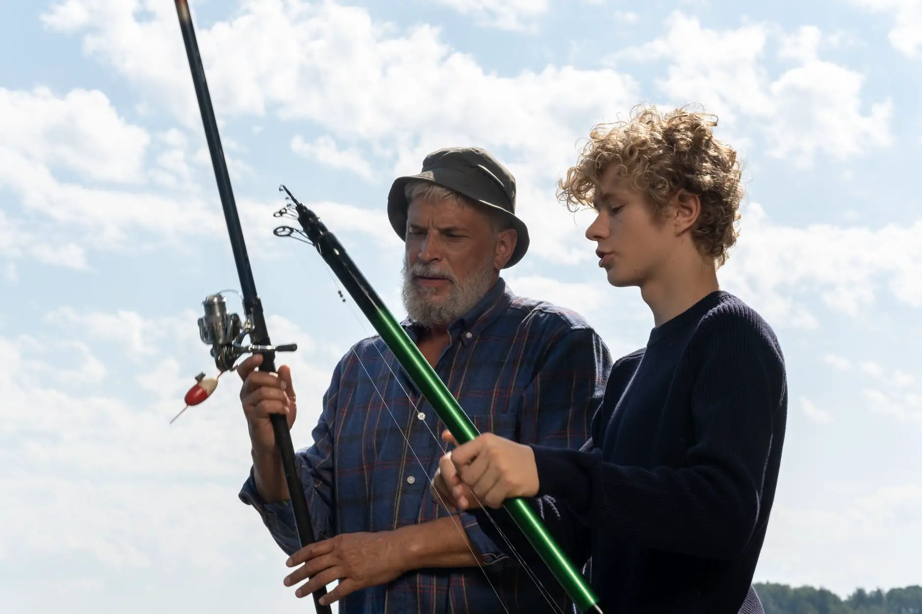 a grandfather and grandson holding their fishing rods