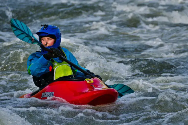 person on kayak paddling in body of water